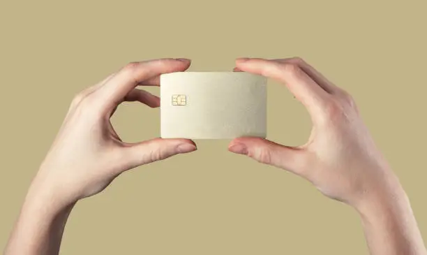 Bank card mockup, gold sample template in both hands. Blank debit credit plastic bankcard with chip. High quality photo