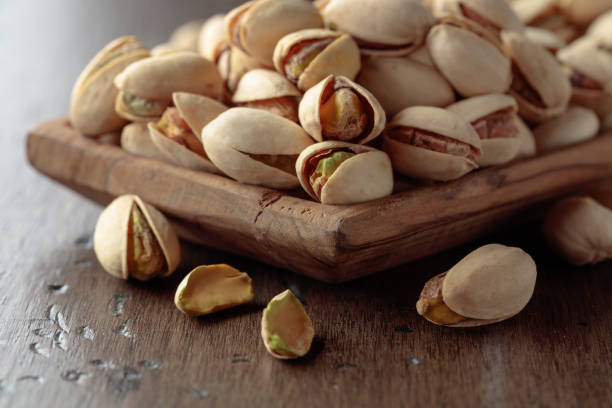 istock Salted pistachios on an old wooden table. 1465206812