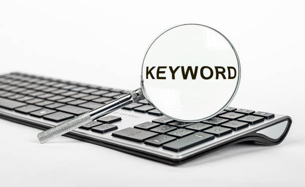 palabra clave en lupa. palabras clave para seo, concepto de marketing - single word keywords seo key fotografías e imágenes de stock