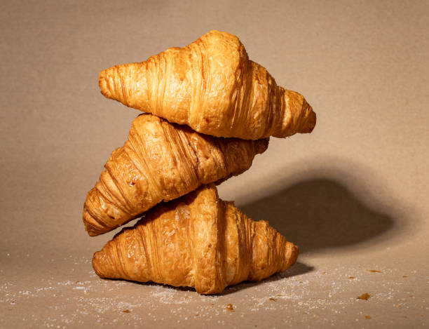 istock Fresh french croissants stack composition. Puff craft bakery on kraft paper 1465207283
