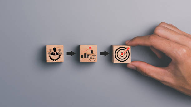 Wooden block in businessman hand and arrow icon hitting center of dartboard target,Setting business goals and focused concepts, Organizational growth and objectives, marketing strategy planning bloque de madera en la mano del hombre de negocios y el icono de flecha que golpea el centro del objetivo de la diana, establecimiento de metas comerciales y conceptos enfocados, crecimiento y objetivos organizacionales, planificación de la estrategia de