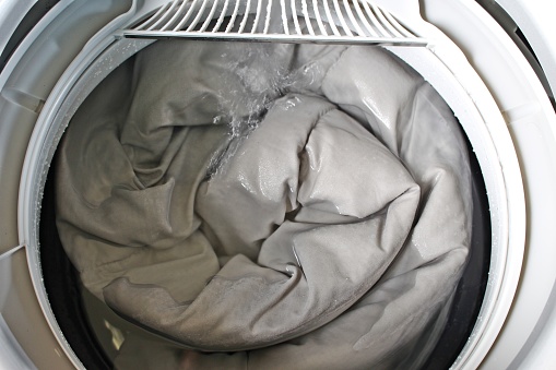 Roll up the duvet and put it in the washing machine.For the presentation of the washing machine.