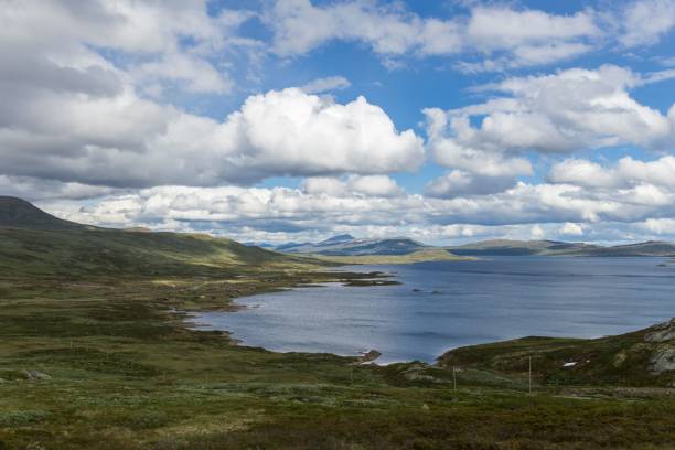 istock Scenic blue lake under fluffy clouds and blue sky in Norway 1465223817