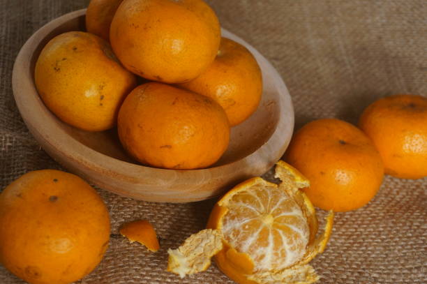 istock Oranges on a wooden bowl and isolated on brown background 1465224051