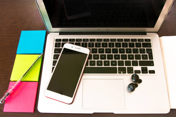 istock One person's workspace at home: laptop, notebook, pen and sticky papers. 1465224412
