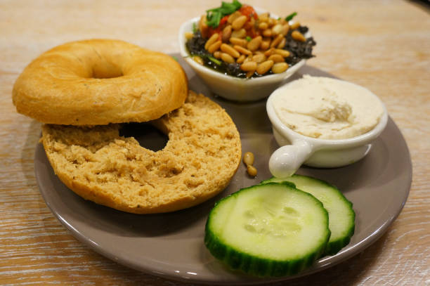 A bagel with pesto, cheese and vegetables