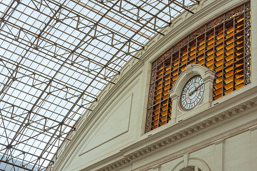 A view of the glass roof and the huge clock of the major railway station in the city of Barcelona