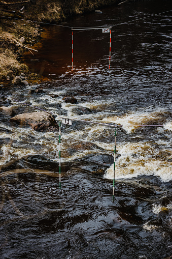 A vertical shot of the gate of whitewater slalom over the rough river