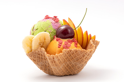 Ice cream scoops of different colors and flavours. Decorated with fresh fruits. Delicious dessert