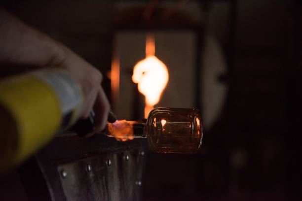 istock Glass blower holding glass mold with high fire for shaping 1465228658