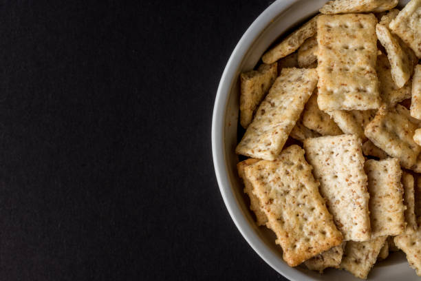 istock Top view of rectangular crackers in the bowl with black background 1465228690