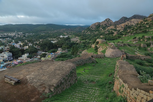 A scenic green and rocky area of Chitradurga Fort and a village on the slope, India