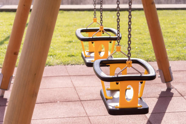 istock Vertical shot of empty swings in a public park 1465230995
