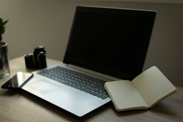 istock Laptop, an open notebook, and a cellphone on an office table 1465231275