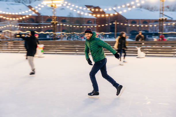 istock Joyful bearded man practices going skating on ice ring, has cheerful expression, smiles happily, demontrates his professionalism. Active sporty male in green jacket go in for winter sport 1465231498
