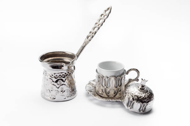 istock Silver coffee pot with a cup and a pomegranate-shape decoration isolated on a white background 1465234367