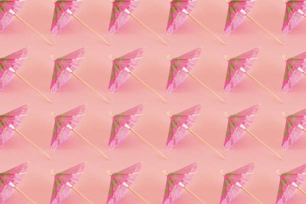 ujęcie pod dużym kątem wzoru z różowymi parasolami koktajlowymi - drink umbrella umbrella pink paper zdjęcia i obrazy z banku zdjęć