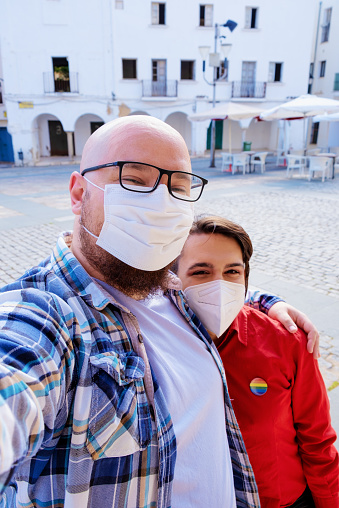 A transgender girl with a friend, taking a selfie with surgical masks