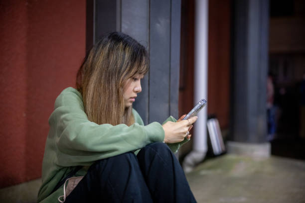istock Young woman sitting and using phone 1465235065