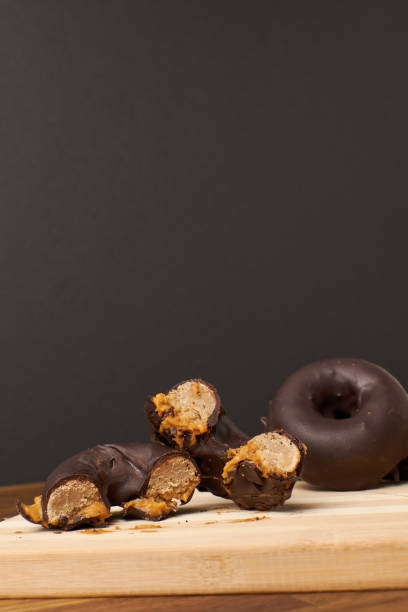 istock Vertical shot of chocolate donuts on a wooden board 1465240687