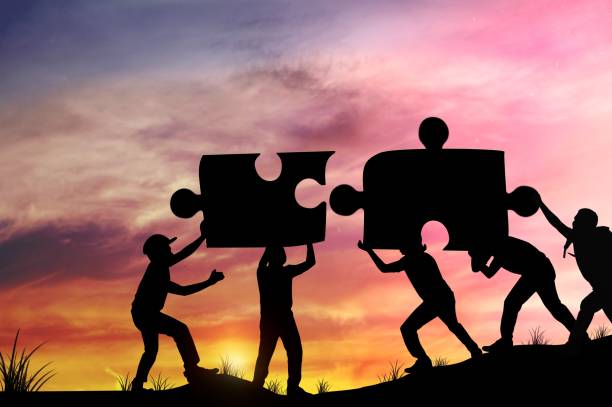 Silhouette people helping to connect jigsaw and puzzle to success, concept as improving and development business stock photo