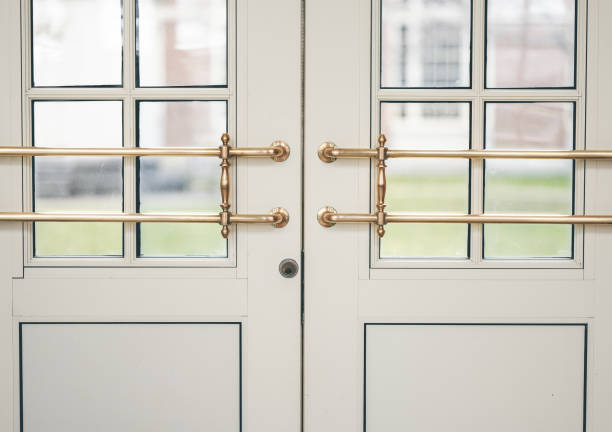 istock Closeup shot of white doors with golden handles 1465243410