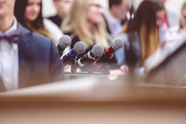 istock Selective focus shot of microphones next to a rostrum on a stage 1465243725