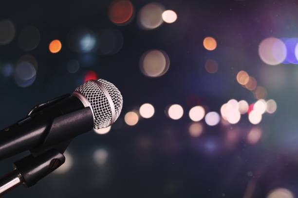 istock Microphone on blur bokeh of light and hall background, Music and singing concept 1465243744