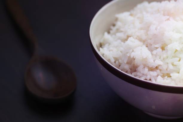 istock Thai rice in bowl with wooden spoon on table 1465246013