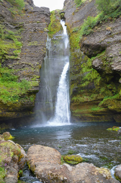 istock Stunning view of foamy waterfall among cliffs partly covered with moss on a gloomy day 1465246298