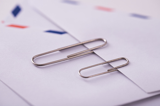A close up shot of two paperclips on an envelope