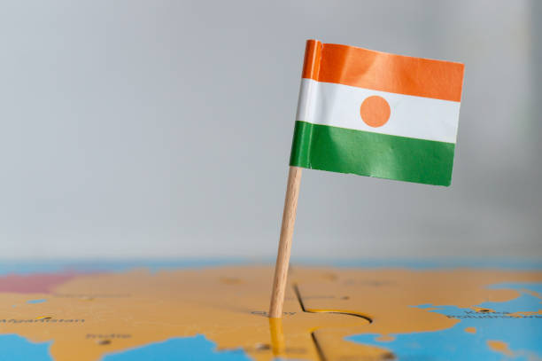 istock Small flag of Niger on a wooden stick fixed on the globe 1465249347