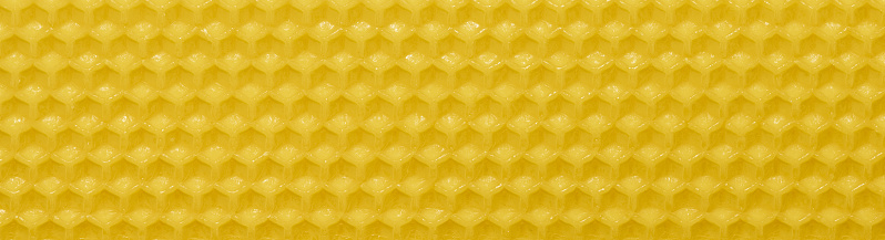 A closeup of yellow pure beeswax comb sheet background
