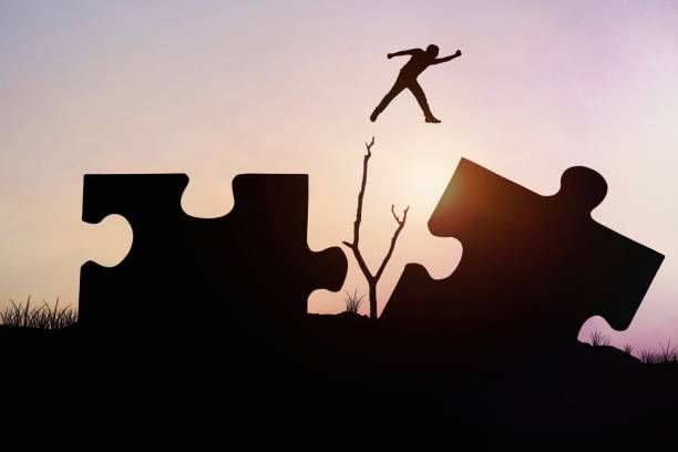 istock silhouette man jumping on jigsaw, concept as can be cross problem and barrier to success in business and finance 1465251372