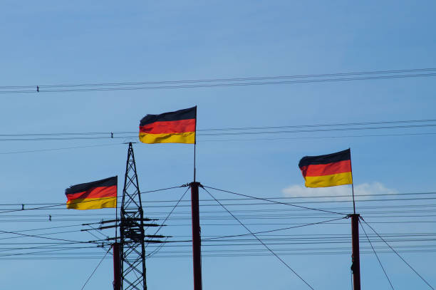 немецкие флаги развеваются перед высоковольтной дорогой - national flag flag global communications sky стоковые фото и изображения