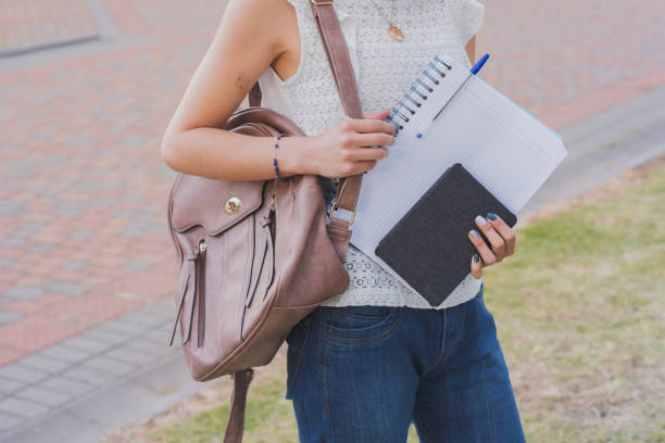 istock Student with a backpack holding notebooks in the park 1465251631