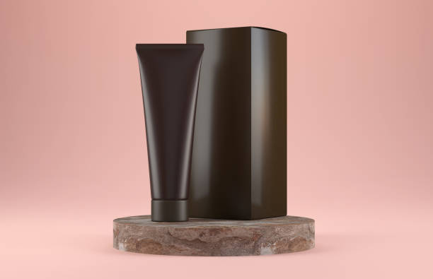 Amber cosmetic tube with packaging on marble podium isolated on pink background