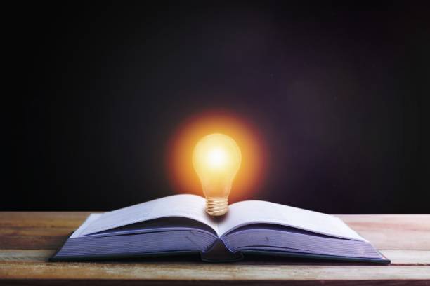 istock Knowledge , idea and education concept, book opening with light bulb on black background 1465254925