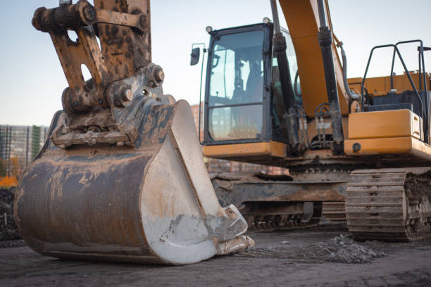 istock The tracked orange backhoe loader is parked with the bucket lowered. The crawler excavator is parked on the street. 1465255183
