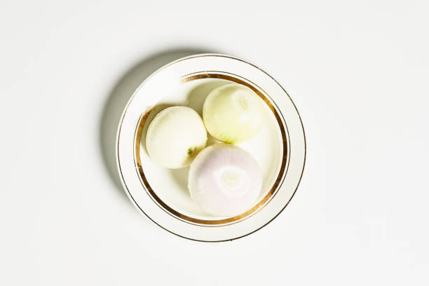 istock Top view of fresh onions on a plate on a white surface 1465256251
