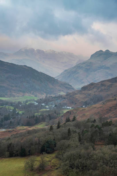 Stunning Winter sunrise landscape view from Loughrigg Fell towards Langdale Pikes and Pike O'Blisco in the Lake District stock photo