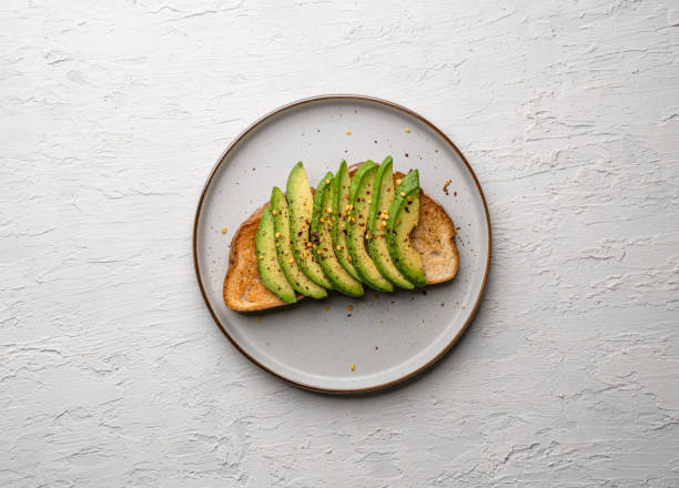 istock Top view of a delicious avocado toast on a white plate on a white surface 1465258257