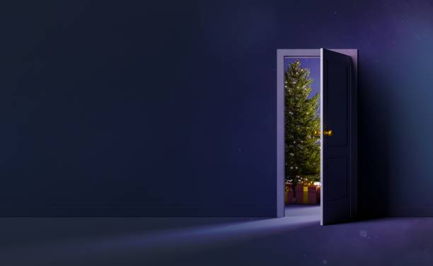 empty wall with open door and christmas tree behind stock photo
