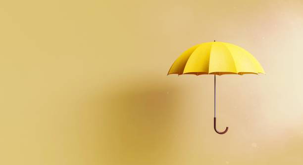istock yellow umbrella on beige background with shadow 1465260431