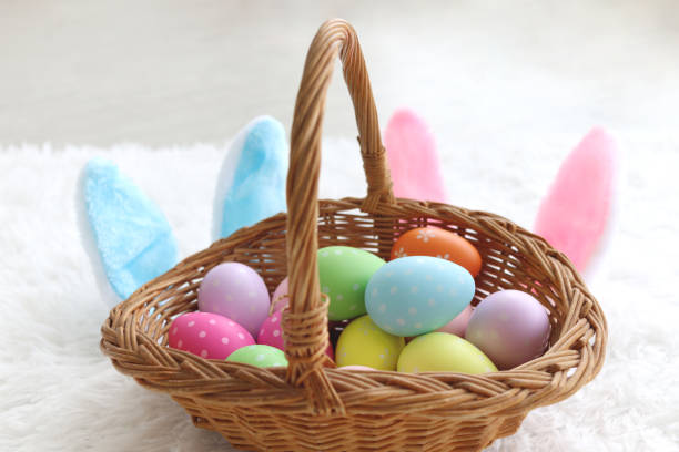 istock Beautiful colorful Easter eggs and bunny rabbit ears headband in wicker basket on fluffy white rug, decoration and celebration spring beginning 1465273013