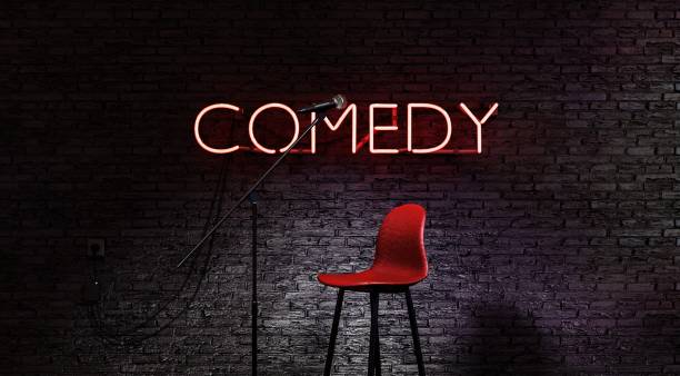 istock stage lit by a spotlight and a red neon lamp with the word COMEDY 1465274141