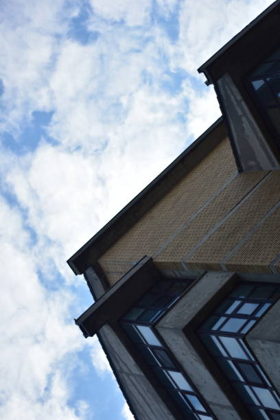istock Close up from below on a building and a cloudy sky above 1465280055
