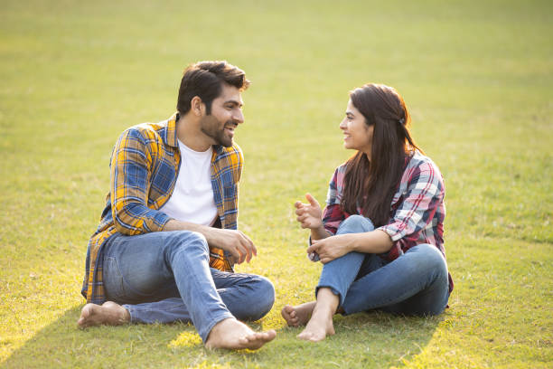 istock Young couple smiling while sitting in park. Stock photo 1465284870