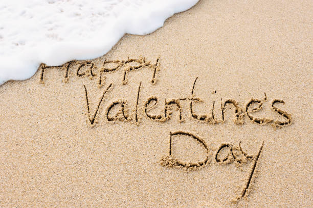 istock Happy Valentine's Day written on sandy beach 1465286235