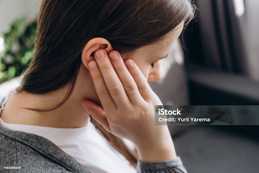 Nahaufnahme einer jungen brünetten Frau, die ein schmerzhaftes Ohr hält und plötzlich starke Schmerzen verspürt. Ungesunde kaukasische Frau 20s leidet an schmerzhafter Otitis auf der Couch zu Hause. Konzept für Gesundheitsprobleme - Lizenzfrei Ohr Stock-Foto Nahaufnahme einer jungen brünetten Frau, die ein schmerzhaftes Ohr hält und plötzlich starke Schmerzen verspürt. Ungesunde kaukasische Frau 20s leidet an schmerzhafter Otitis auf der Couch zu Hause. Konzept für Gesundheitsprobleme - Lizenzfrei Ohr Stock-Foto